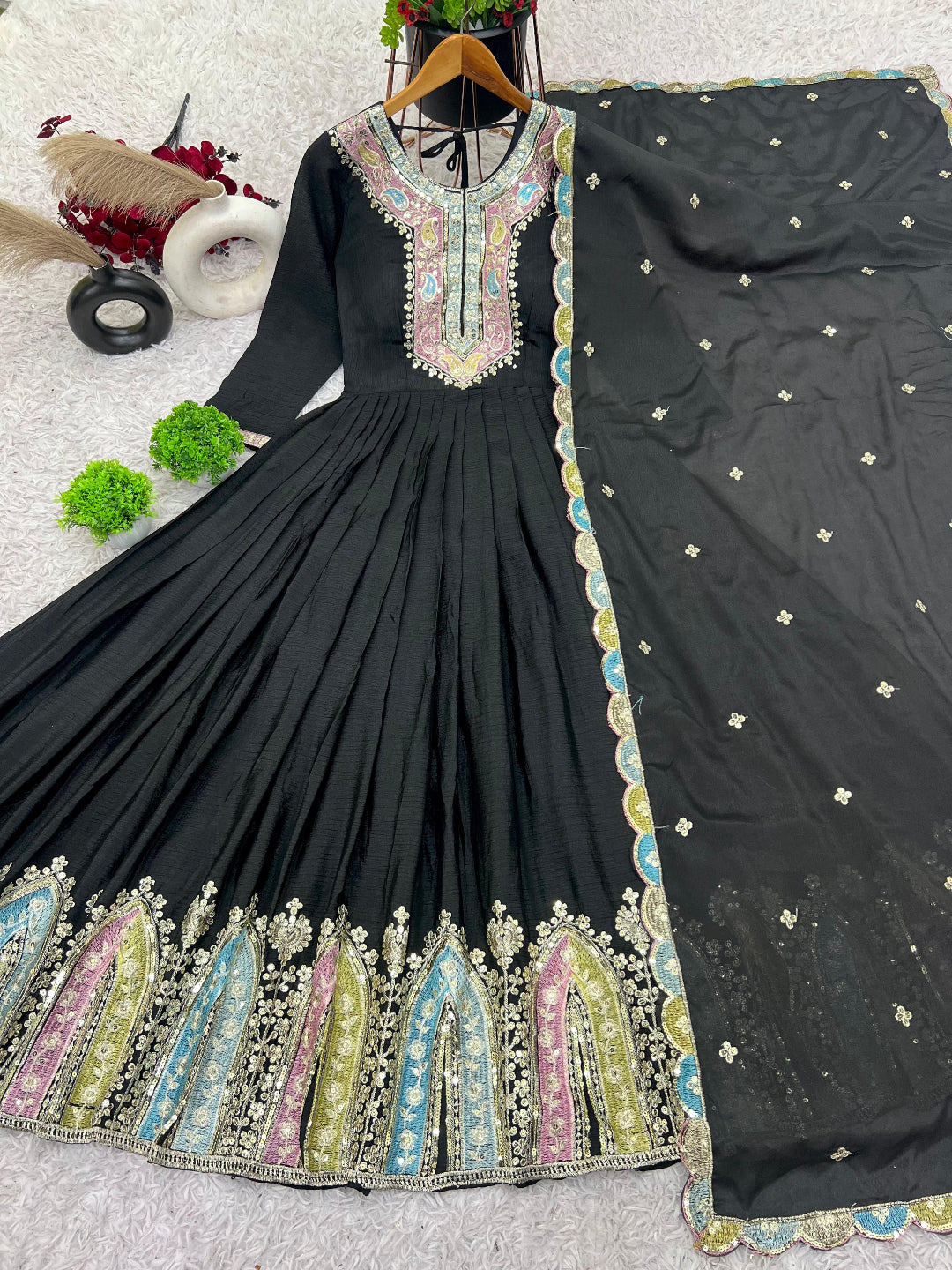 Black embroidered dress with colorful patterns on a light gray background