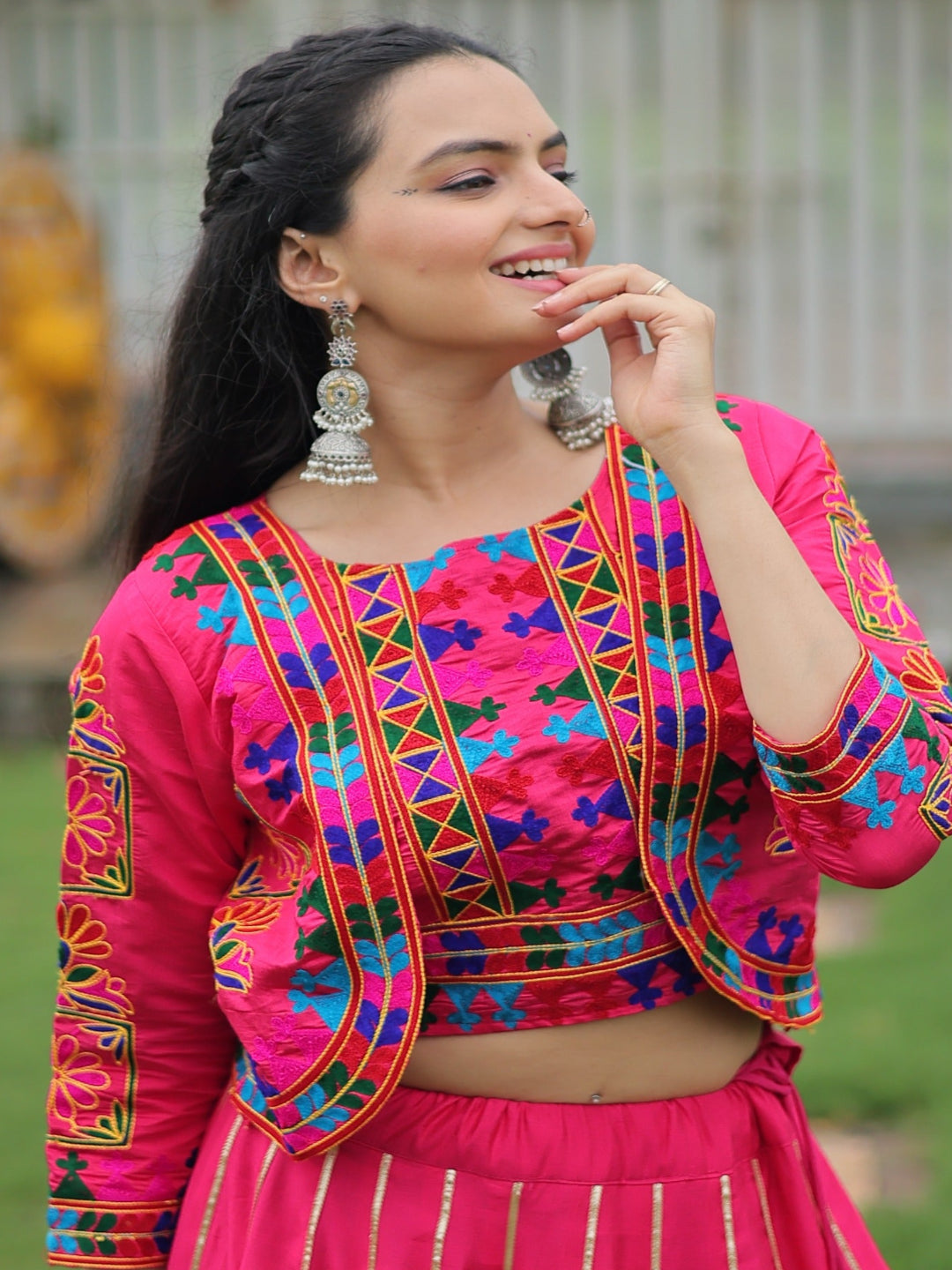 Woman wearing a colorful traditional outfit with a blurred outdoor background
