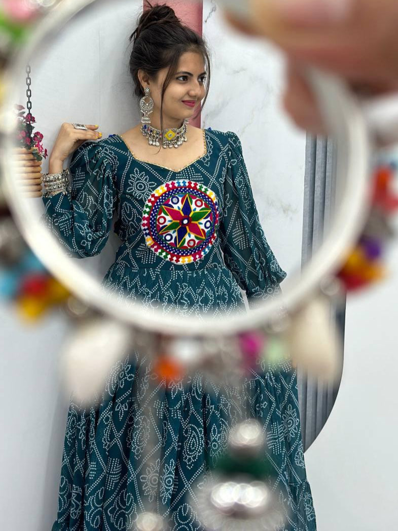 Woman wearing a colorful traditional outfit with a decorative mirror in front of her.