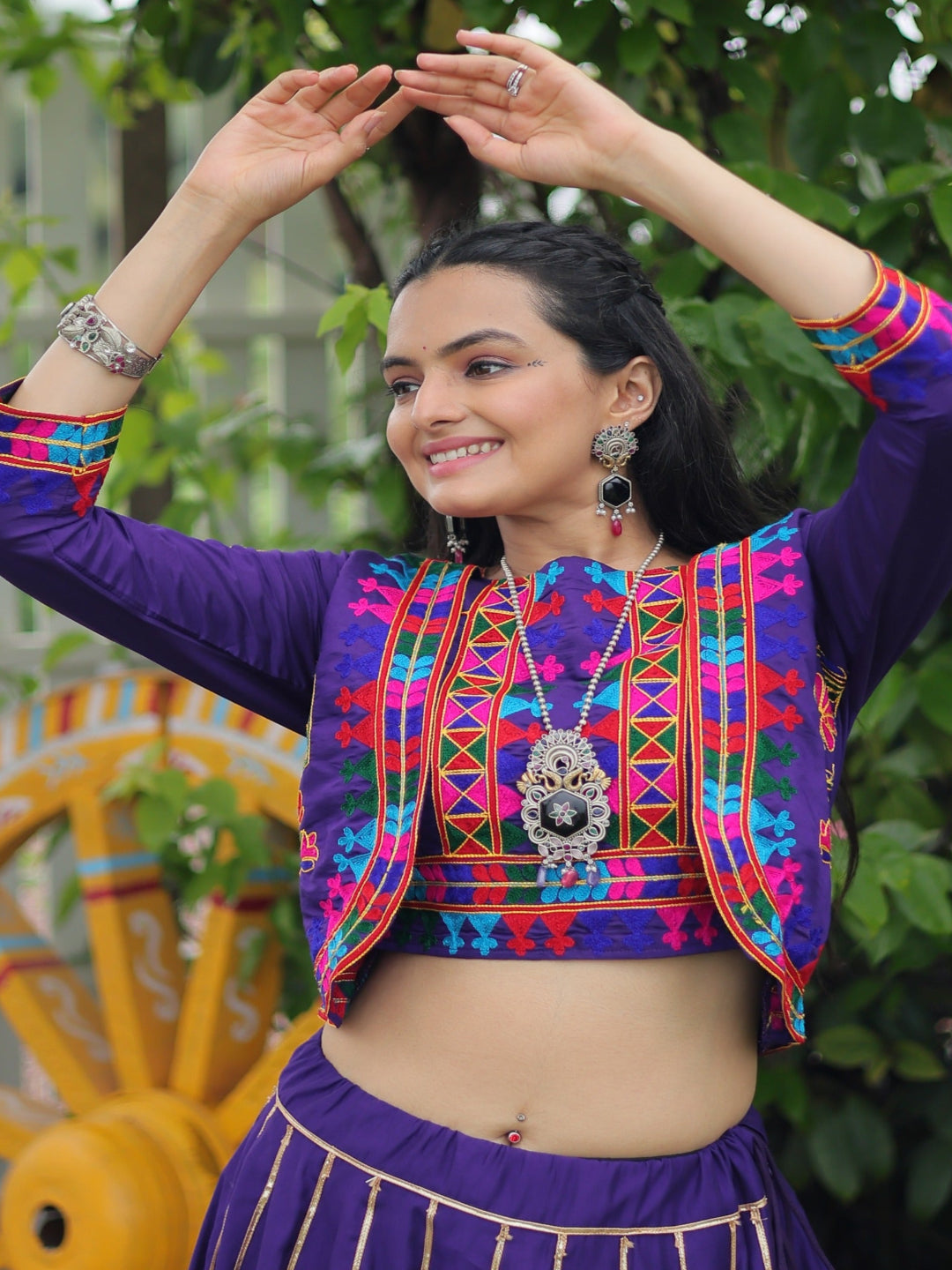 Woman in traditional colorful outfit with a decorative background