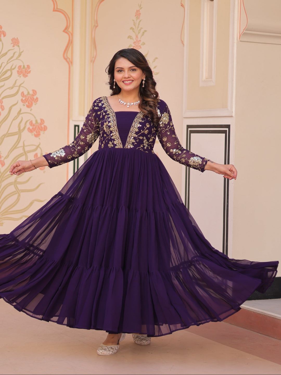 Woman in a purple gown with floral patterns in an indoor setting