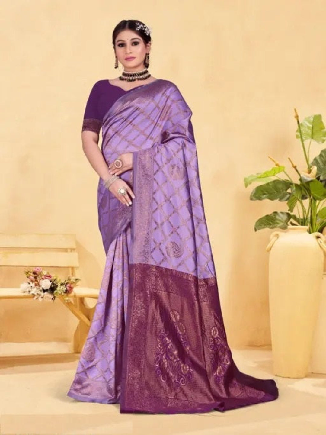 Woman wearing a purple saree with a matching blouse against a beige background