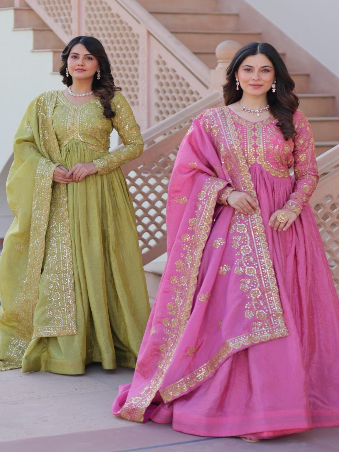 Two women in traditional embroidered dresses standing on a staircase.