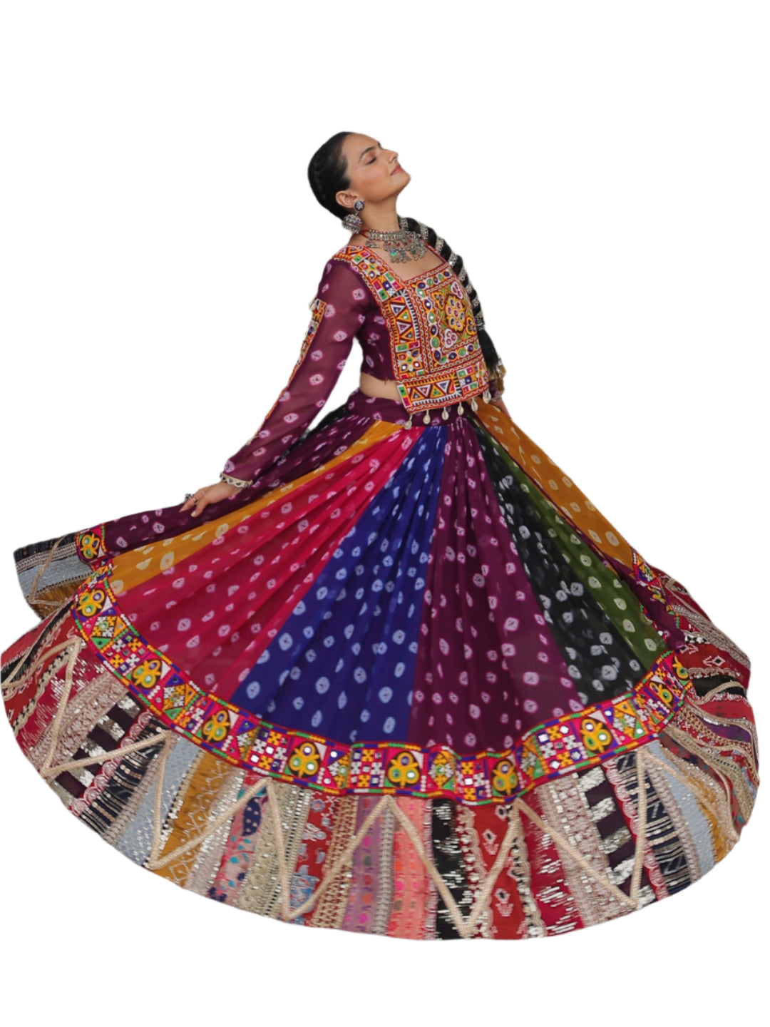 Woman in a colorful traditional outfit sitting on a stone floor with an archway in the background.