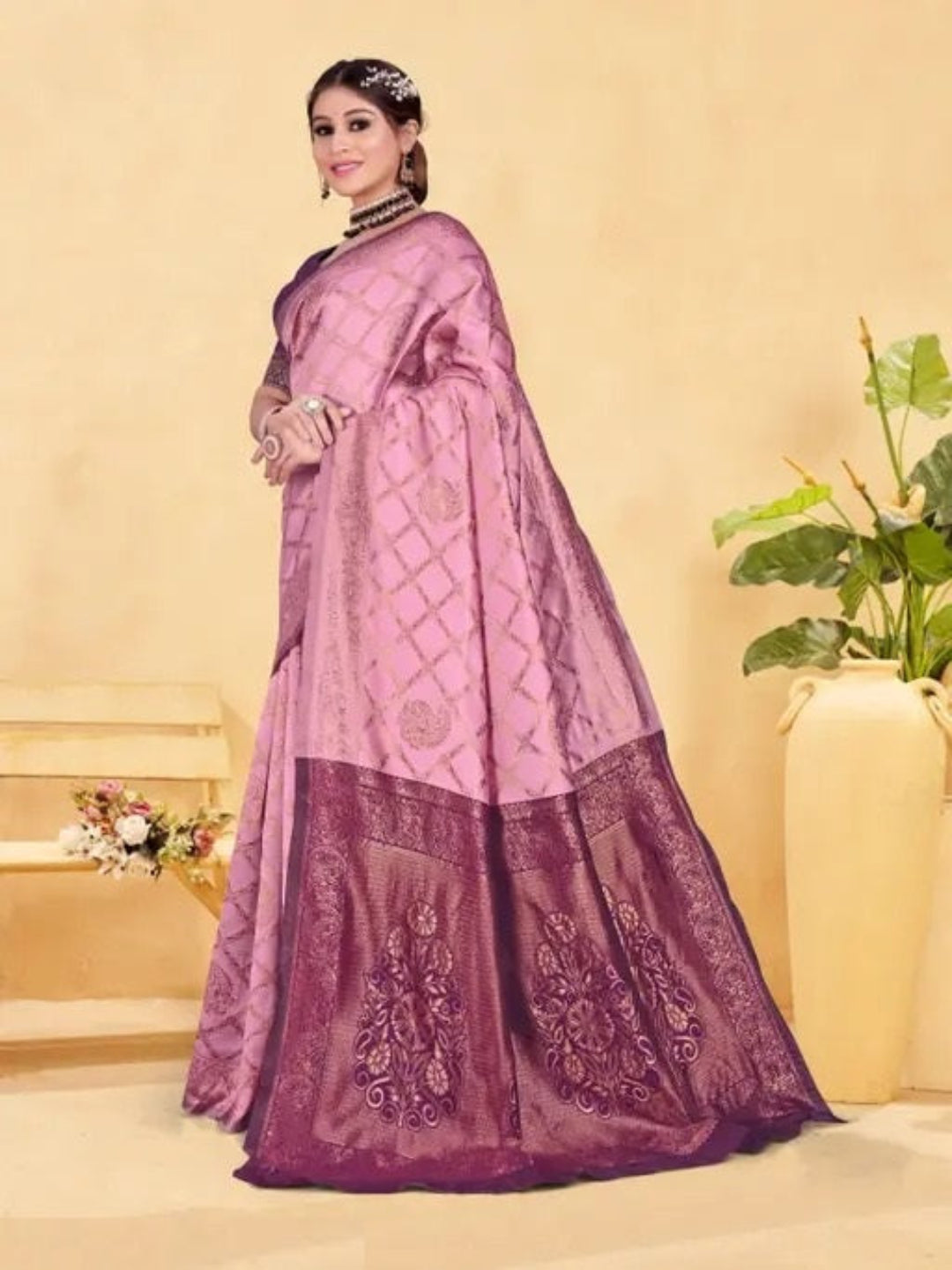 Woman wearing a pink and purple saree with a neutral background