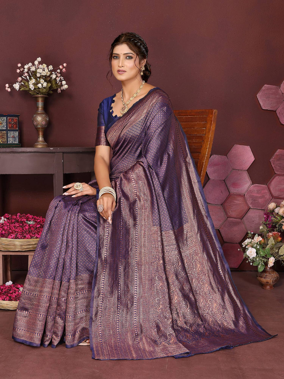 Woman wearing a purple saree with a floral background