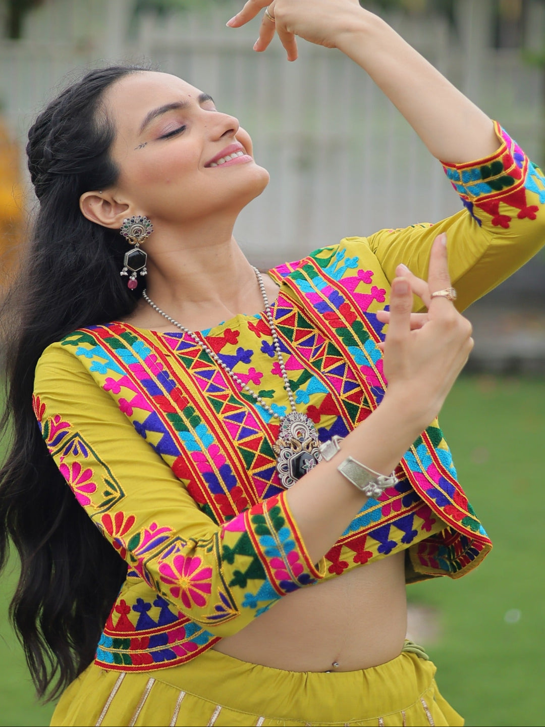 Woman in a colorful traditional outfit with a blurred outdoor background