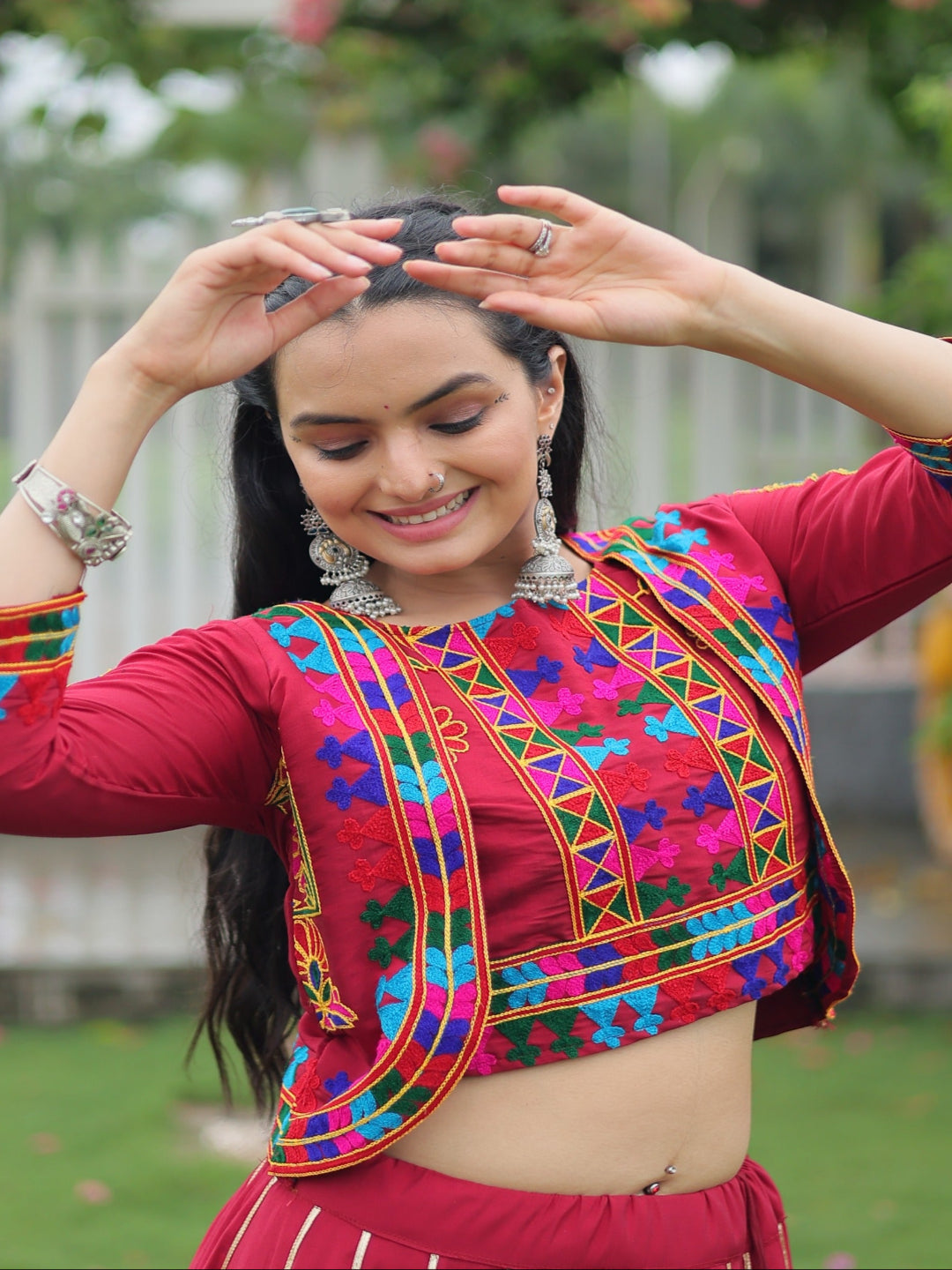 Woman in traditional colorful attire with a blurred garden background