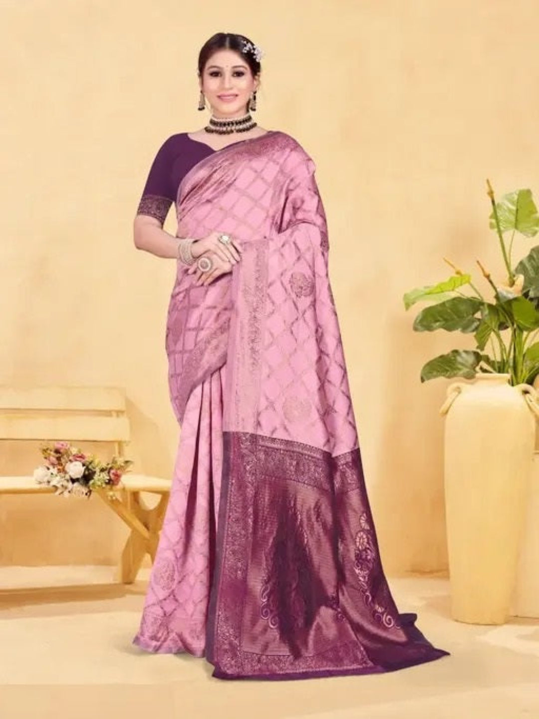 Woman wearing a pink and purple saree with a neutral background