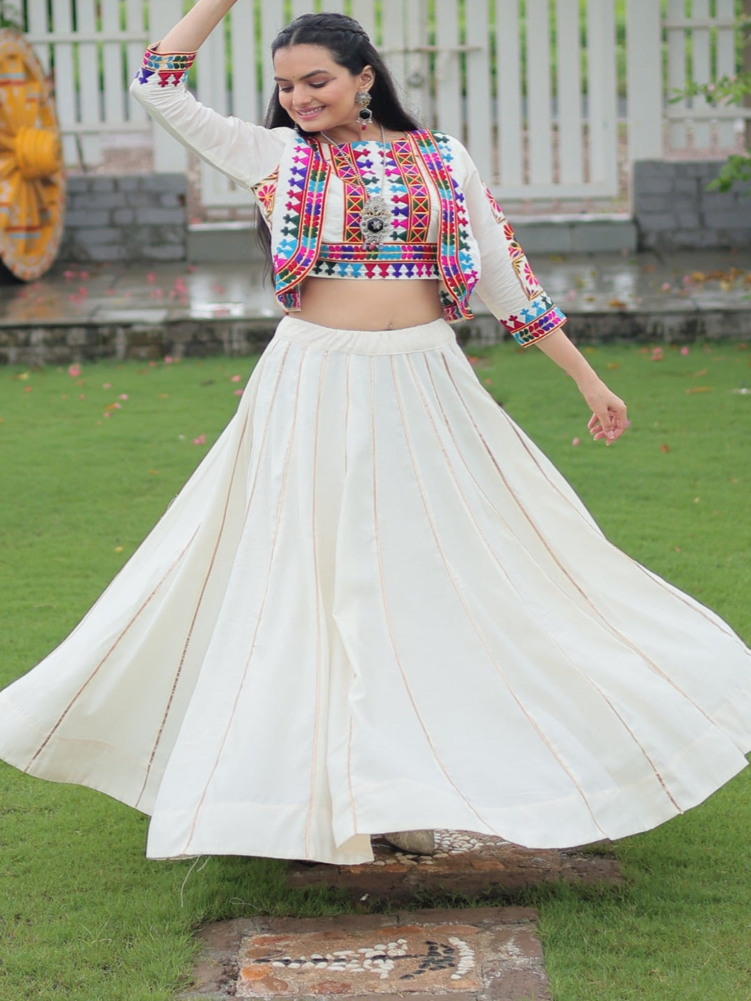 Woman in traditional outfit dancing in a garden setting