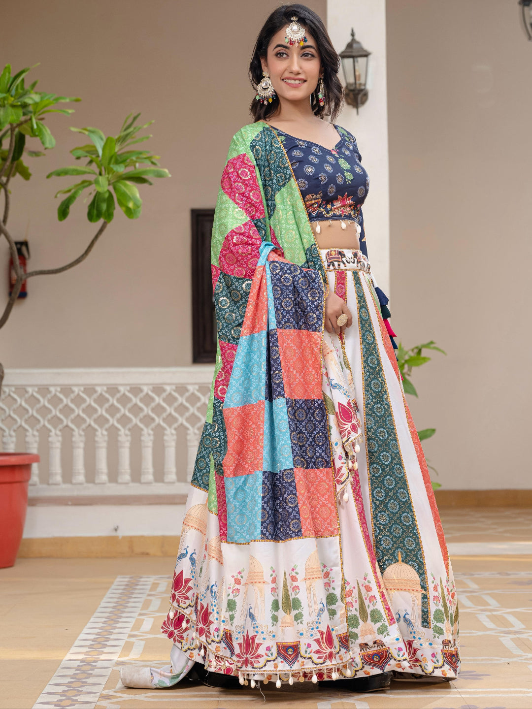 Woman wearing a colorful traditional outfit with a patterned design indoors.