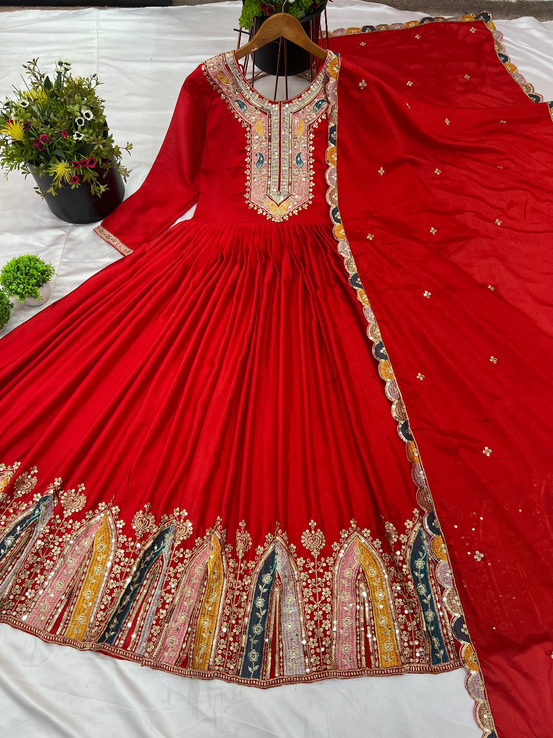 Red embroidered traditional outfit on a white background
