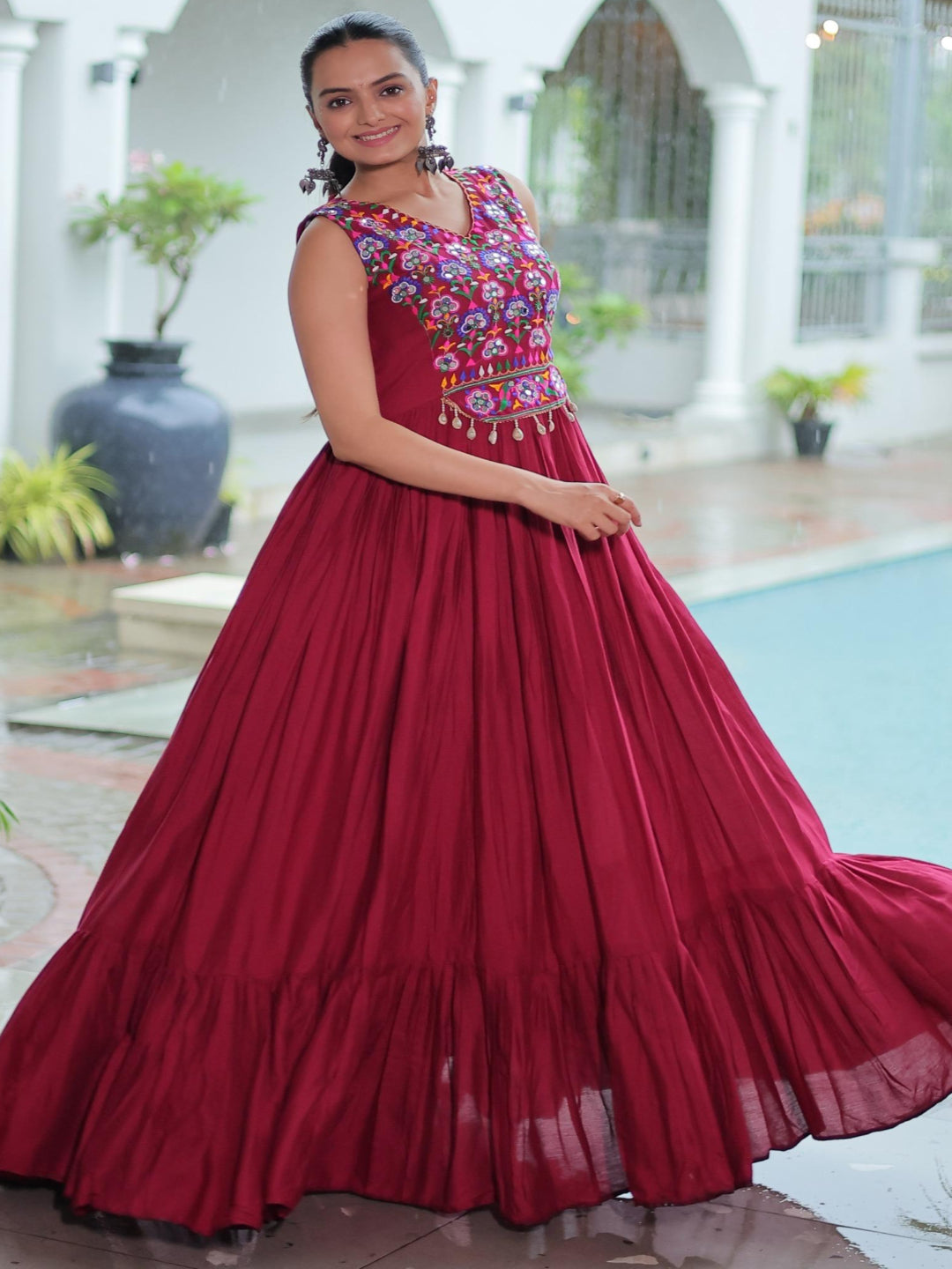 Woman in a red traditional outfit with floral top in an outdoor setting