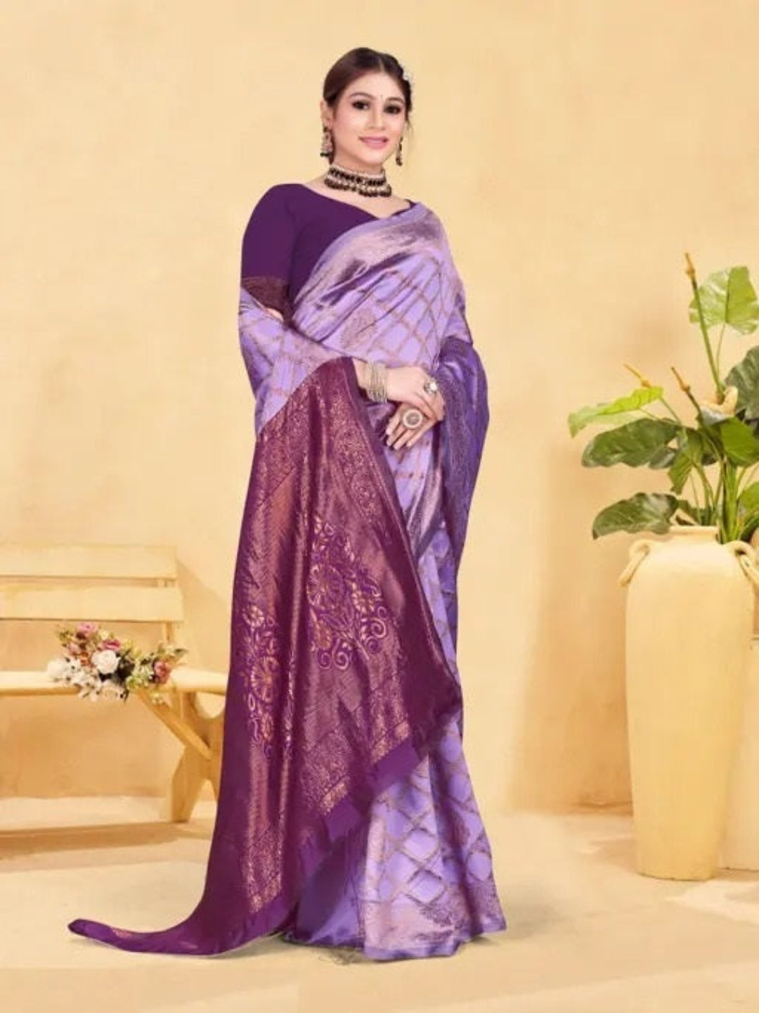 Woman wearing a purple saree with a plant and vase in the background