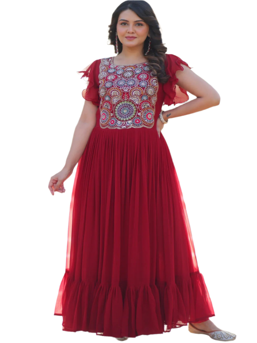 Woman in a red dress with intricate patterns standing in front of a decorative archway.