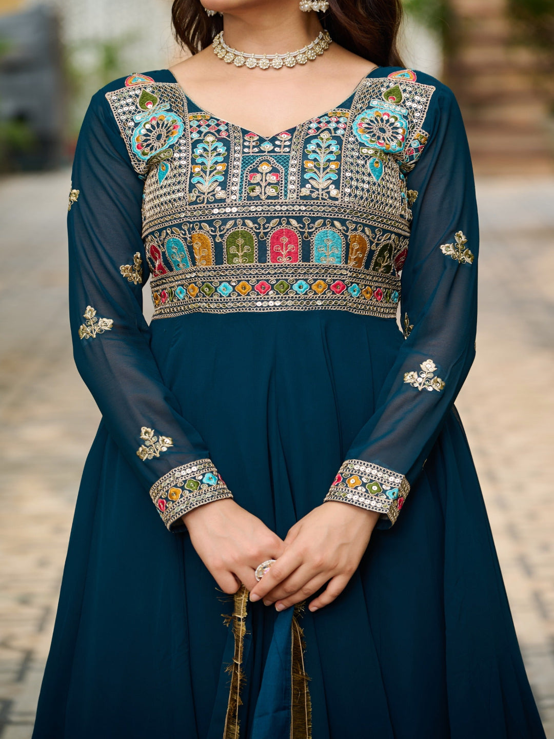 Navy blue dress with colorful embroidery and a necklace.