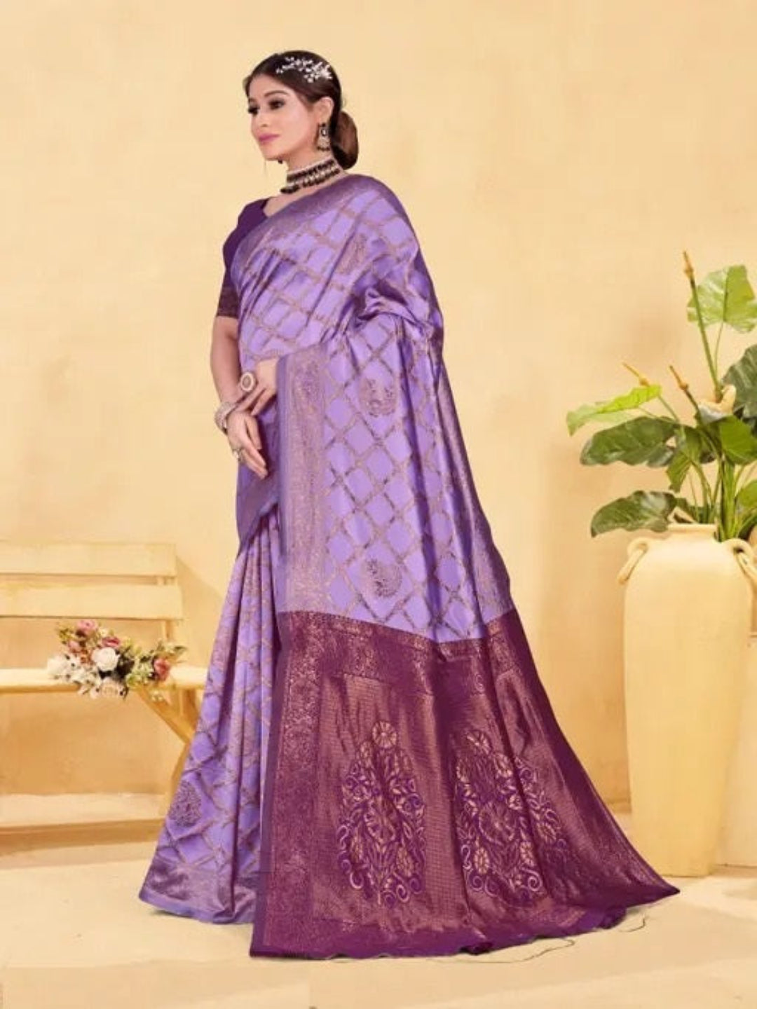 Woman wearing a purple saree with a matching blouse against a beige background