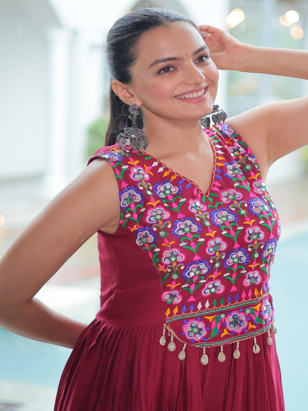 Woman wearing a colorful embroidered top with a blurred background