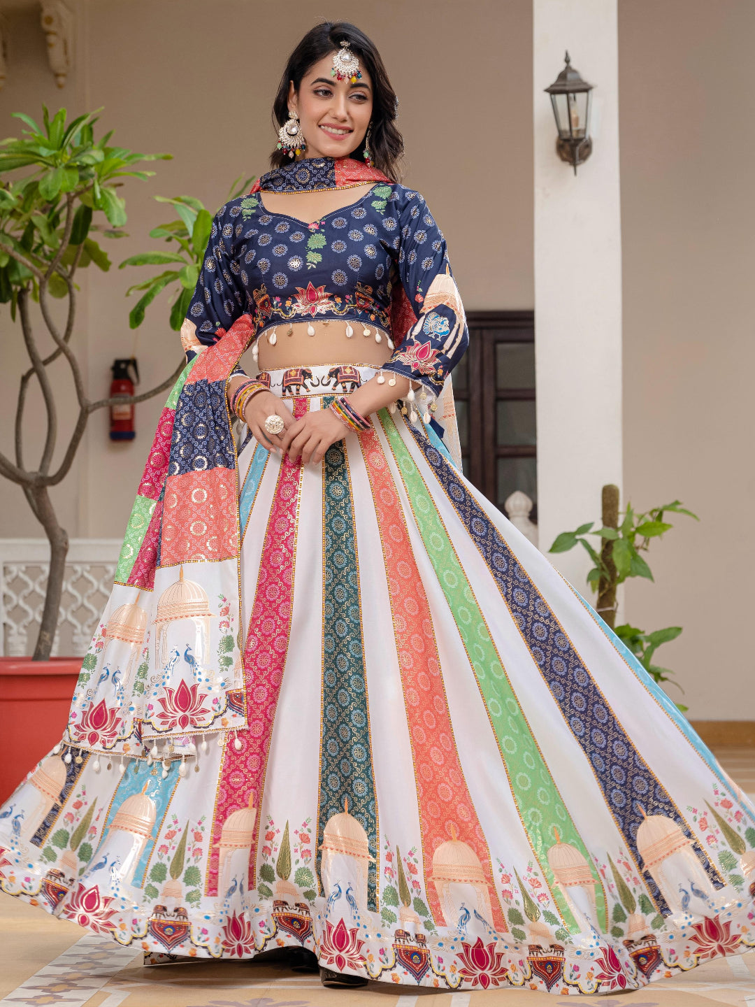 Woman in a colorful traditional outfit standing indoors with decorative elements.
