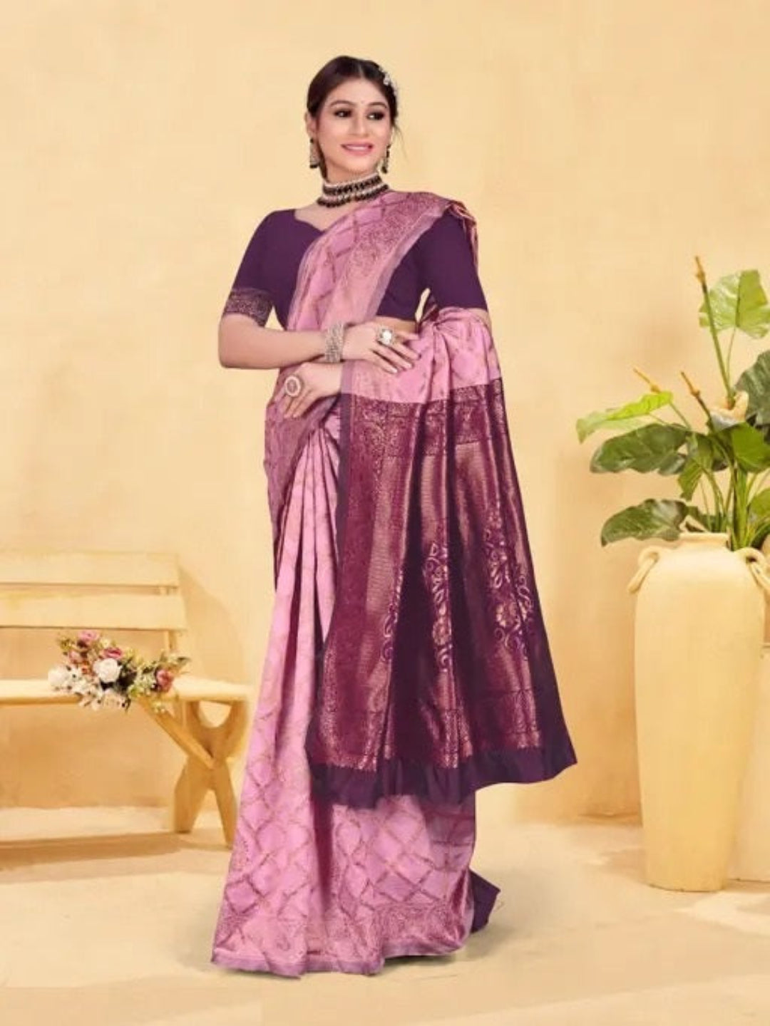 Woman wearing a purple saree with a matching blouse against a beige background
