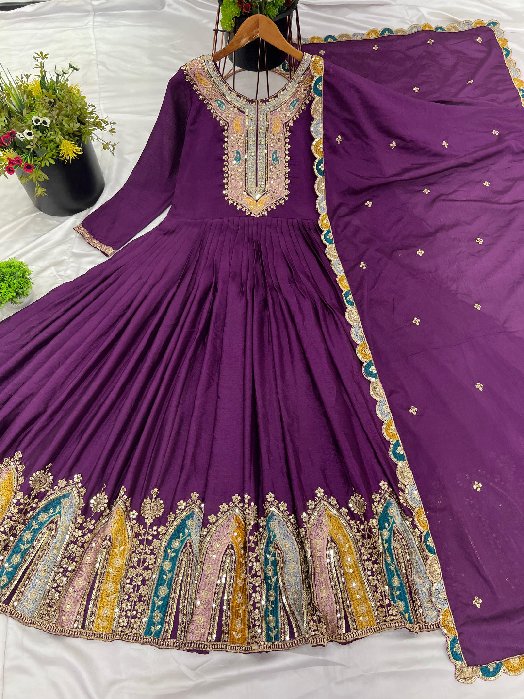 Purple traditional outfit with intricate embroidery on a white surface.