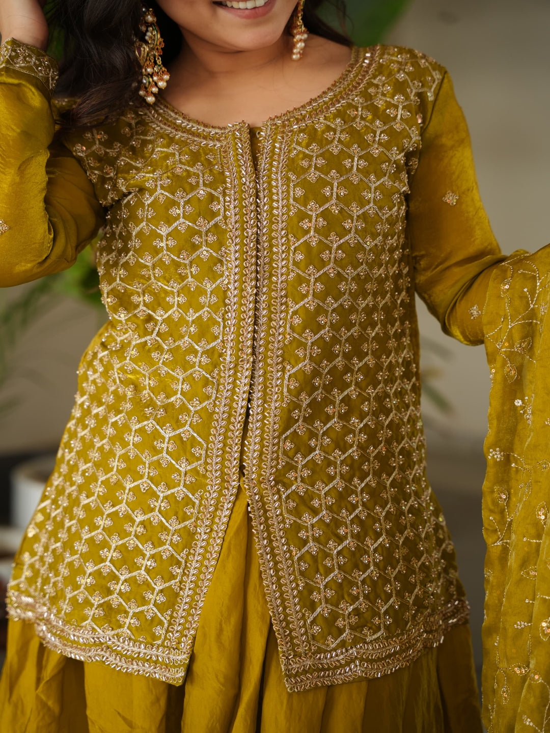 Yellow traditional outfit with intricate patterns on a blurred background