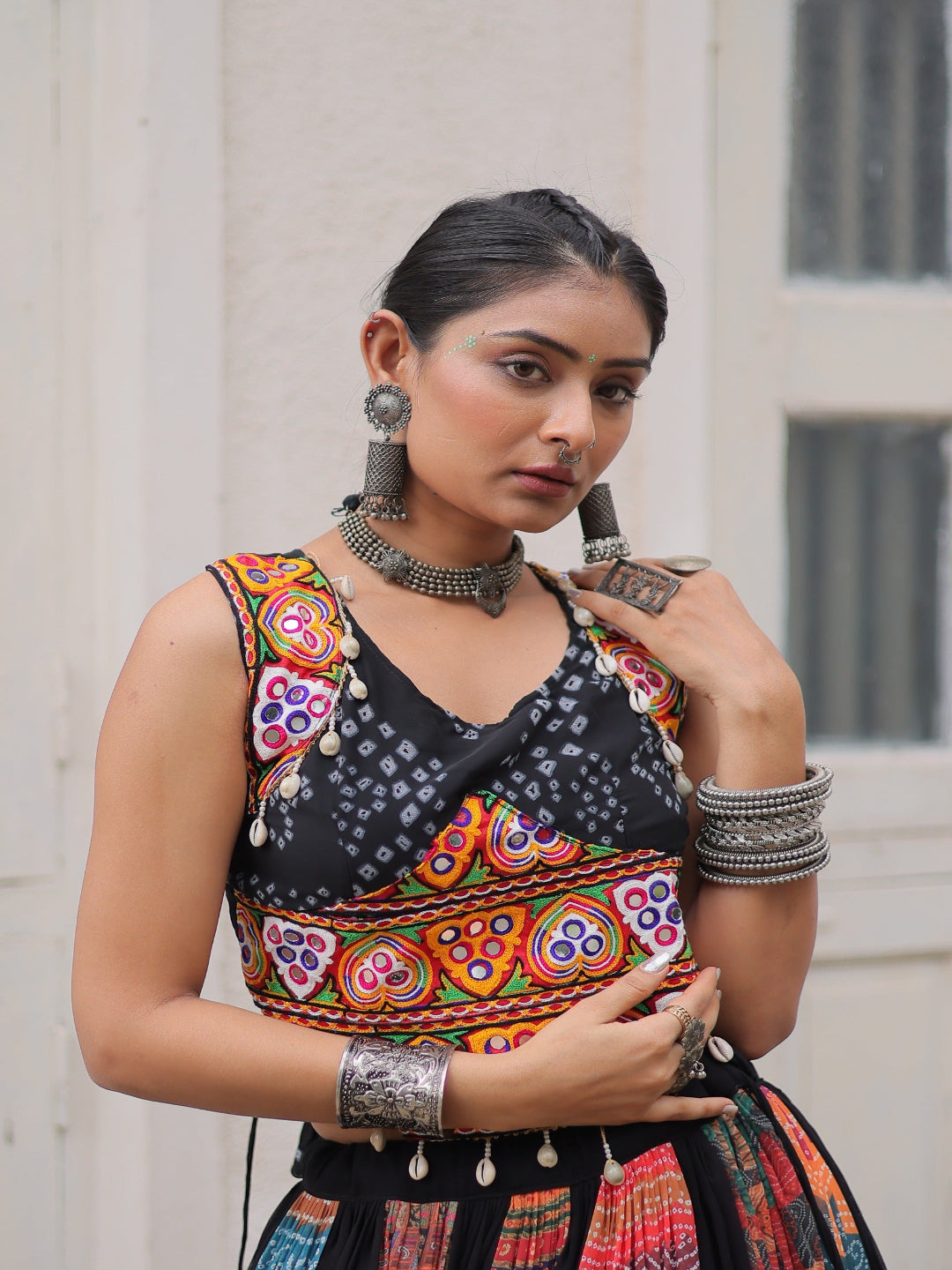 Woman wearing a colorful traditional outfit with intricate patterns and jewelry.