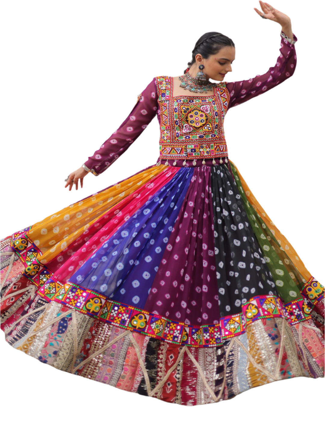Woman in a colorful traditional outfit with a patterned dress, standing in front of a white wall with windows.