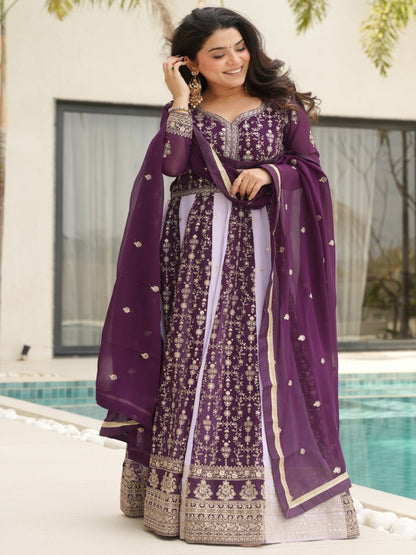 Woman in a purple traditional outfit standing by a poolside.