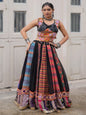 Woman wearing a colorful traditional outfit in front of a white door with arched windows.