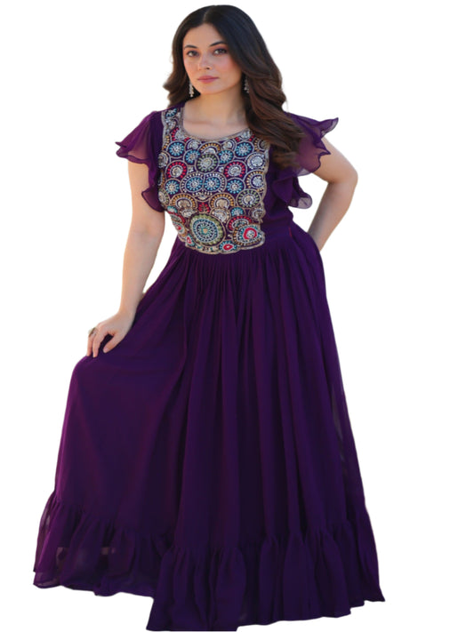 Woman in a purple dress with a floral top standing outdoors.
