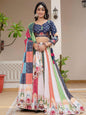 Woman in a colorful traditional outfit standing indoors with plants in the background