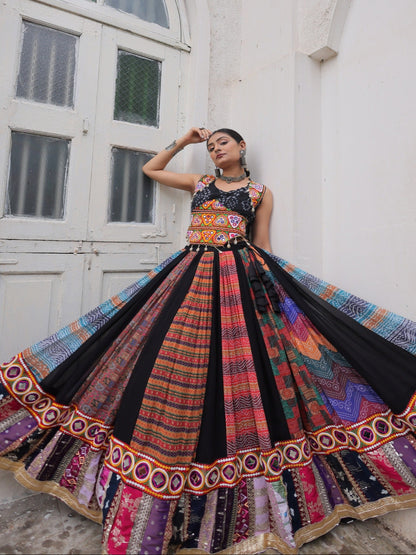 Woman in a colorful traditional outfit standing in front of a white building with arched doorways.