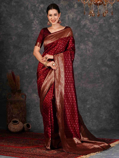Woman wearing a red saree with gold patterns against a dark background