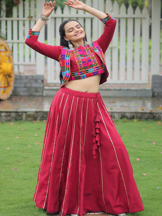 Woman in traditional red outfit with colorful blouse dancing in a garden