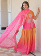 Woman wearing a traditional outfit with a pink and orange dupatta in an indoor setting.