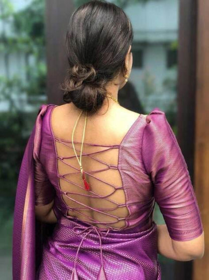 Purple saree with intricate back design worn by a person, blurred background
