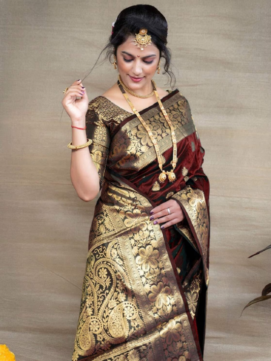 Woman wearing a traditional saree with gold and black patterns on a neutral background