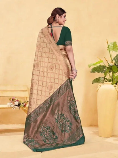 Woman wearing a saree with a green blouse against a beige background