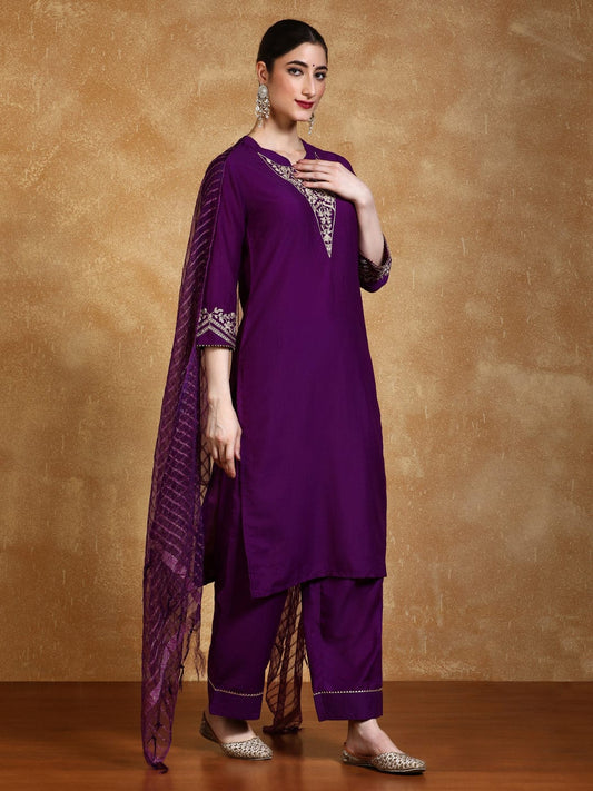 Woman wearing a purple traditional outfit with a brown background