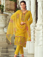Woman wearing a yellow embroidered traditional outfit in an elegant indoor setting.